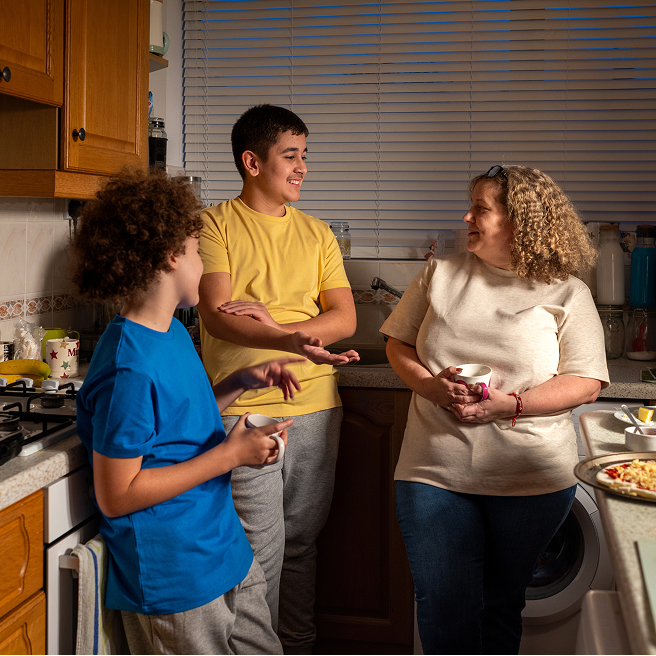 Parent and young person talking in a kitchen